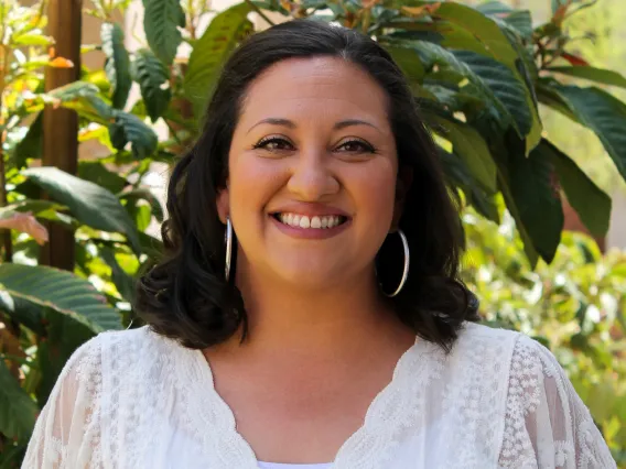 Woman with short brown hair wearing a white blouse.