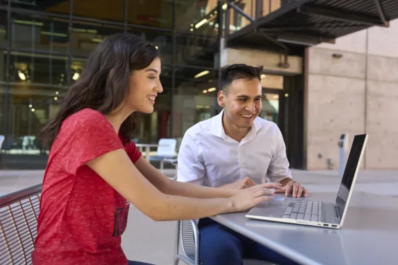 Image of two students looking at a computer