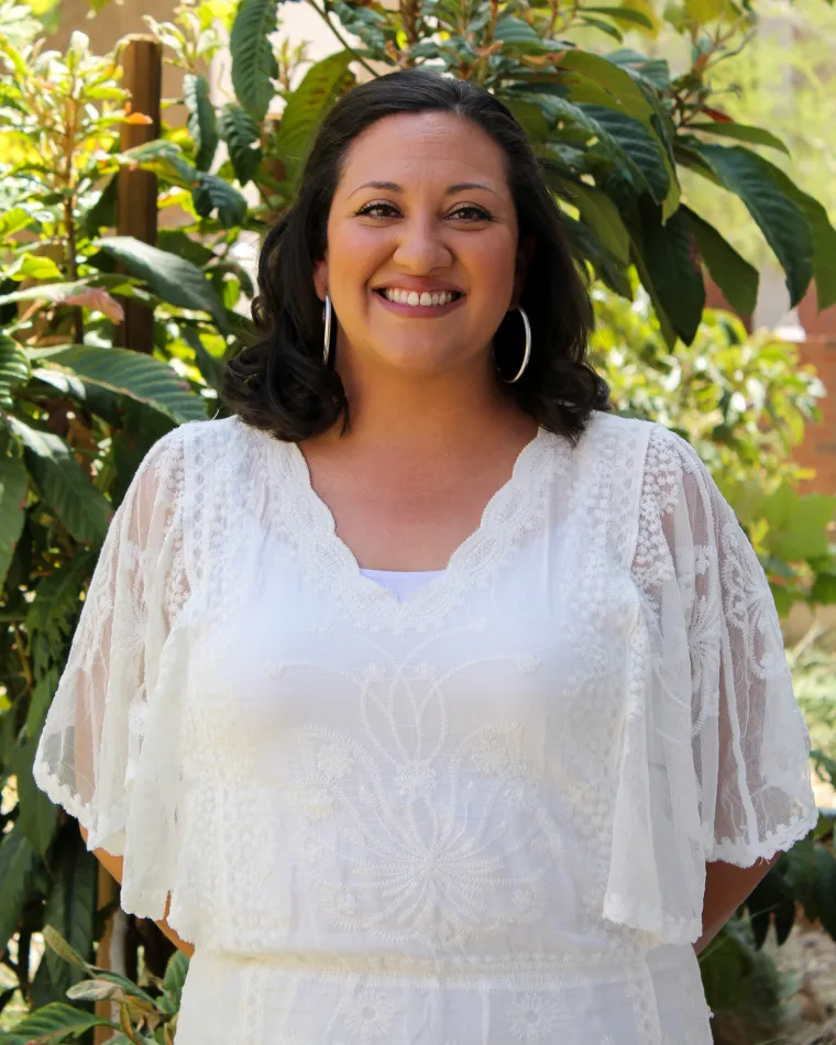 Woman with short brown hair wearing a white blouse.